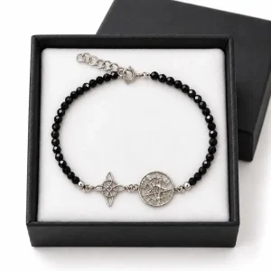 Pulsera de turmalina negra facetada con Nudo de Brujas y Pentagramatón de plata, sobre almohadilla blanca en caja negra.